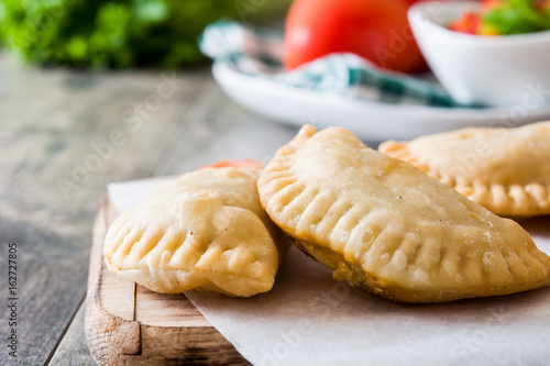 Typical Spanish empanadas on wooden table 