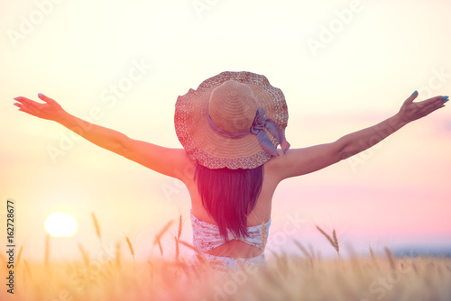 Woman feeling free, happy and loved in a beautiful natural setting at sunset photo