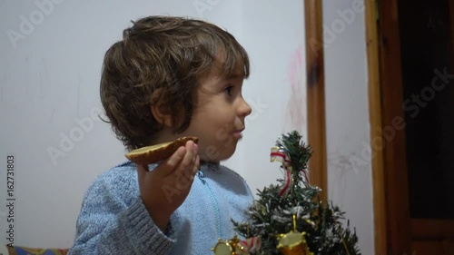 4K Child eats bread and butter on Christmas eve photo