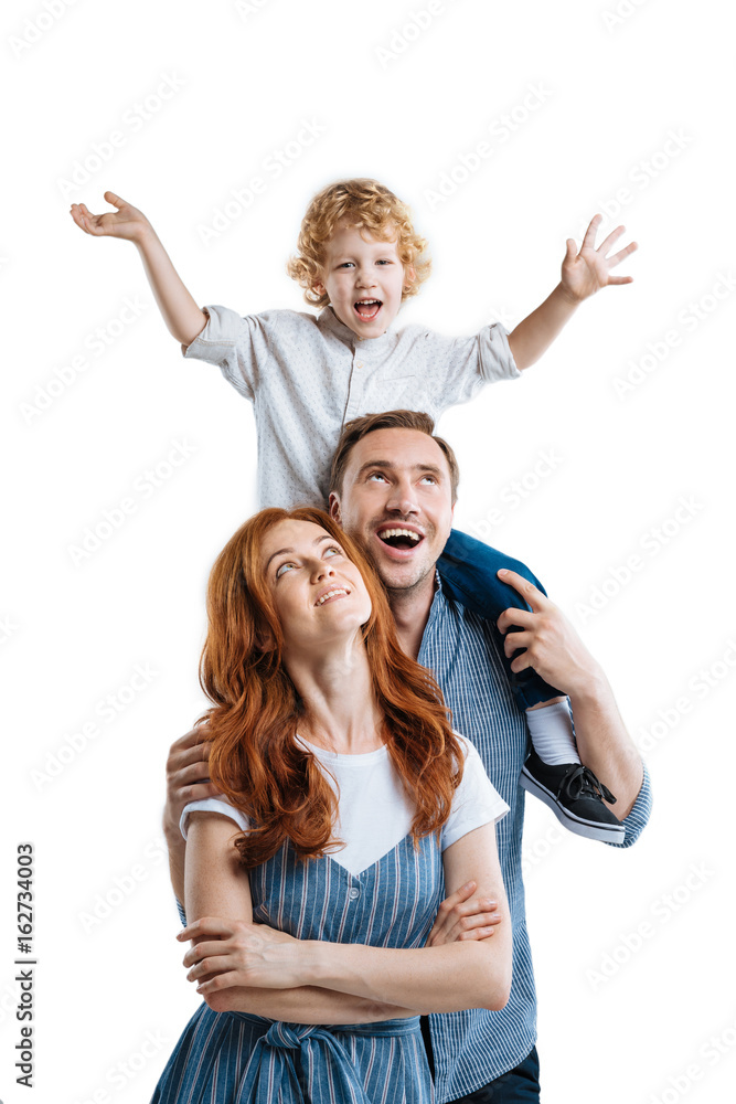 Happy young parents with adorable little son smiling and looking away isolated on white Happy young parents with adorable little son smiling and looking away isolated on white