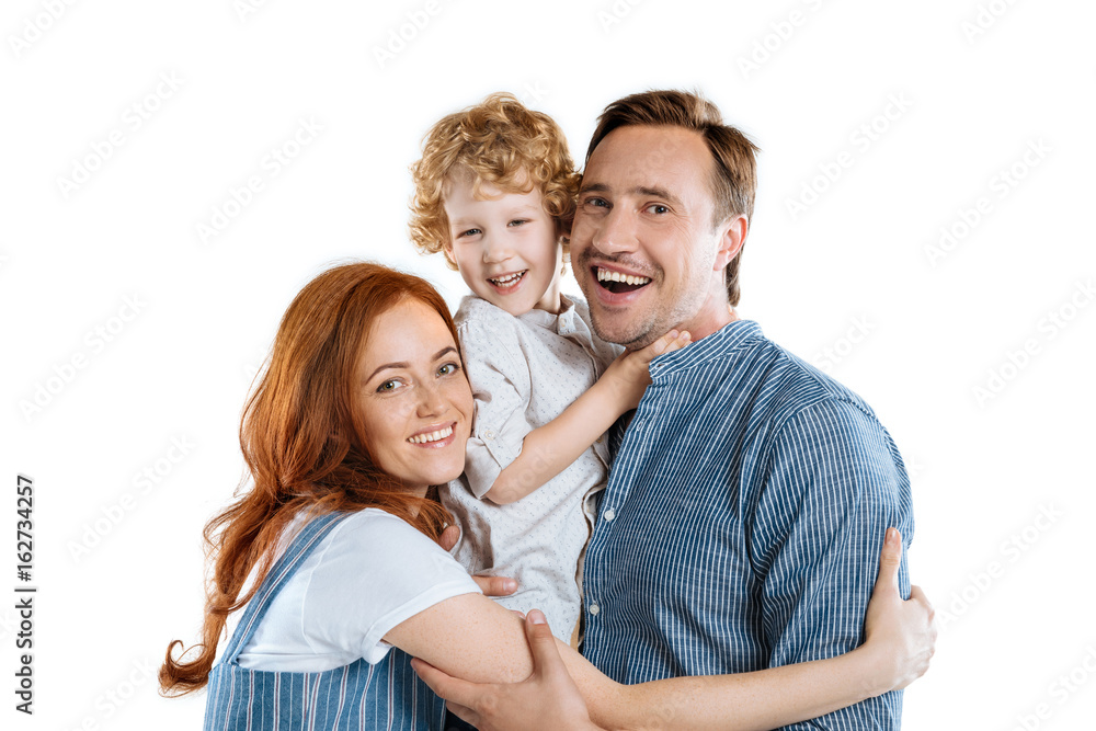 Happy family with one child hugging and smiling at camera isolated on white Happy family with one child hugging and smiling at camera isolated on white