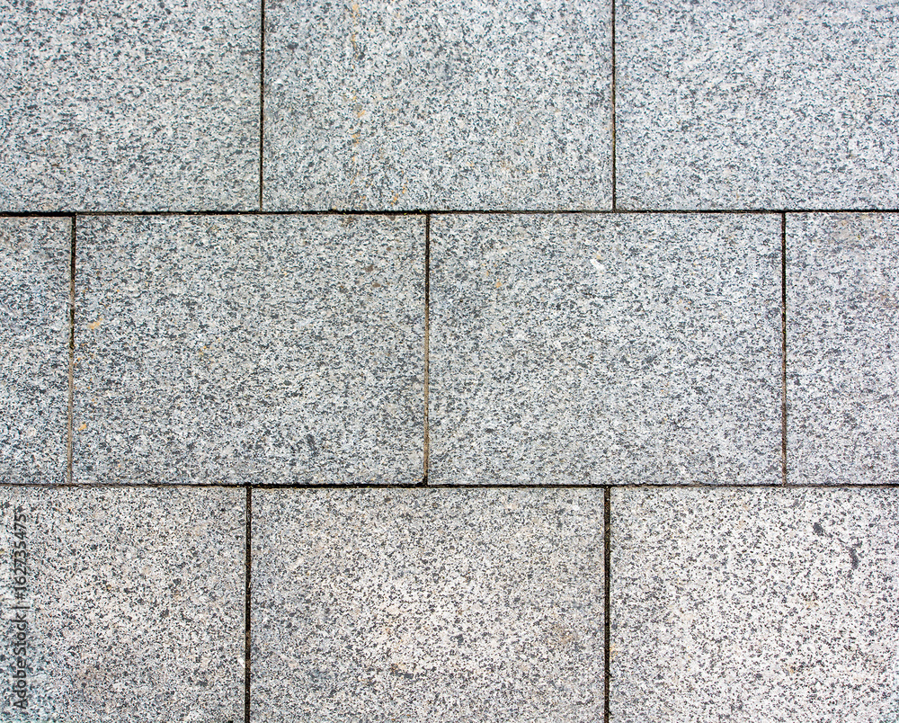 Area laid out of paving stone. Background texture relief. Area laid out of paving stone. Background texture relief.
