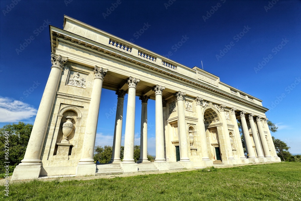 Rajstna colonnade in the middle of the grass field in strong perspective