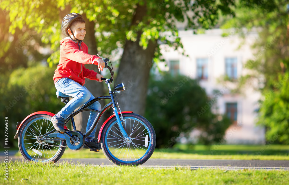 child on a bicycle at asphalt road in summer. Bike in the park child on a bicycle at asphalt road in summer. Bike in the park