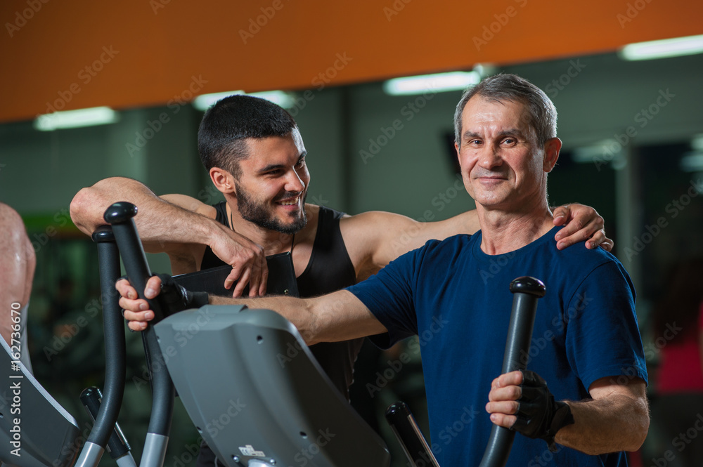Happy senior man working with personal trainer Happy senior man working with personal trainer
