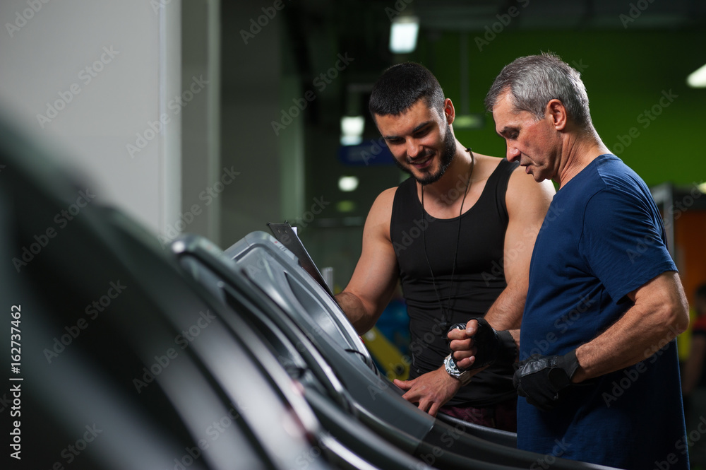 Smiling personal trainer working with senior man Smiling personal trainer working with senior man