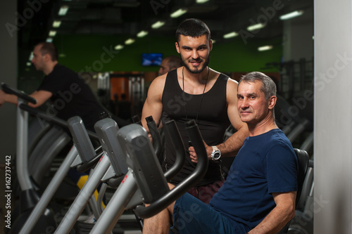 Smiling personal trainer working with male client