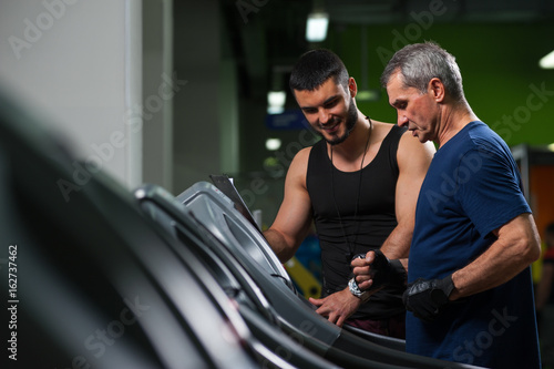 Smiling personal trainer working with senior man