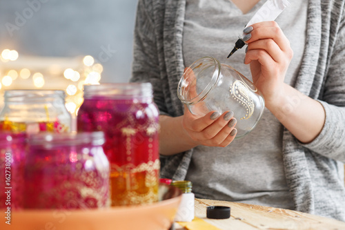 Fotografie Woman decorating jars