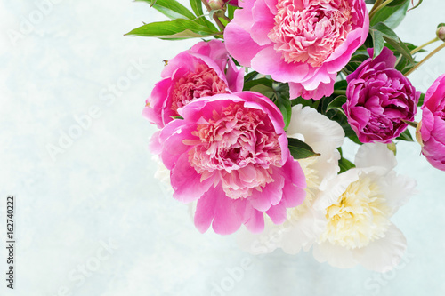 Peonies. Beautiful bouquet of pink white and purple peonies in vase on bright background. Closeup shot selective focus. Wedding bouquet, mothers day gift, women's day gift