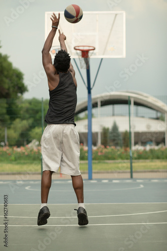 African american man plays on basketball court. Real and authentic activity. © antgor
