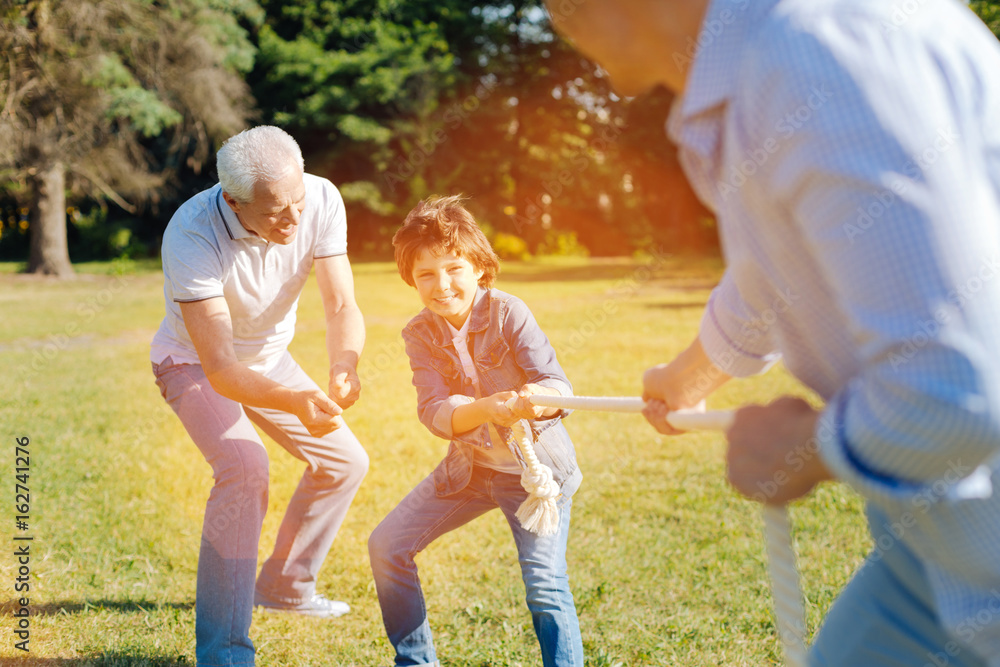 Fototapeta premium Enthusiastic committed fun men tugging the rope