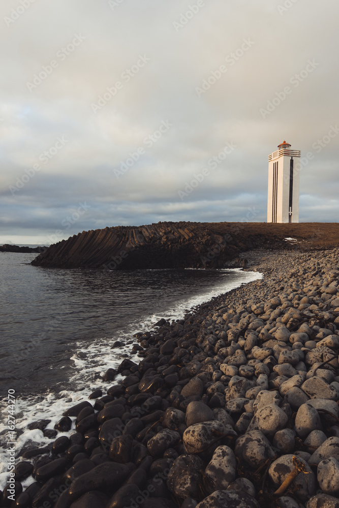 Kálfshamarsvik lighthouse among basalt columns in Iceland
