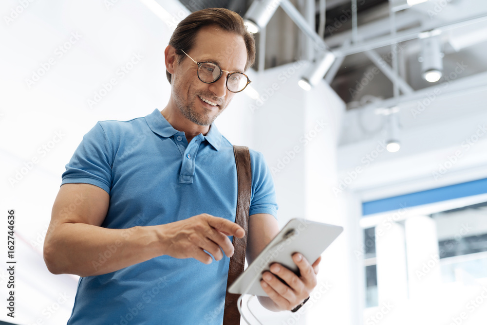 Low angle shot of businessman shopping for tablet computer Low angle shot of businessman shopping for tablet computer