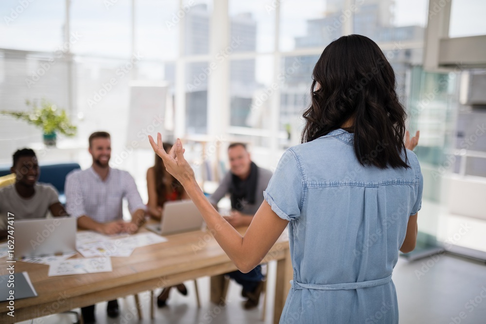 Fototapeta premium Female executive explaining business plans to his coworkers