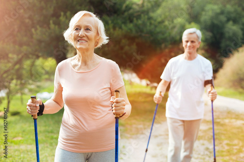 Happy elderly woman hiking with her husband