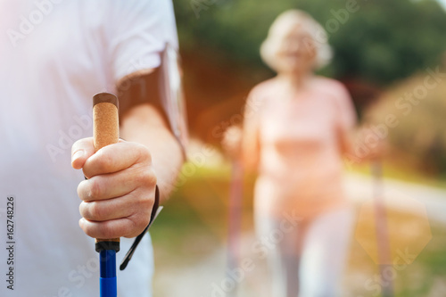 Elderly mans hand holding a walking pole