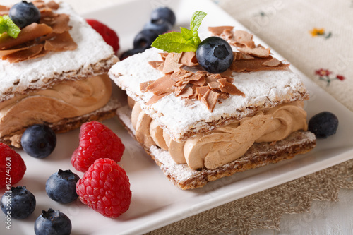 Beautiful dessert: chocolate cake with coffee cream, raspberries and blueberries macro. horizontal
