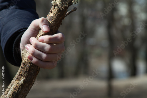 Carefree childhood. wooden stick in children's hand at sunny spring day.