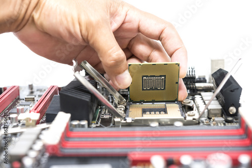 Hand holding CPU show  the ic surface and have motherboard open socket mount for cpu isolated on white bakcground