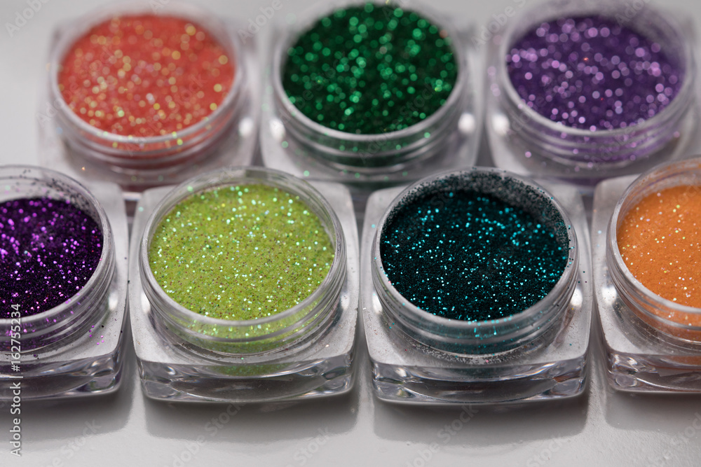 Closeup set of colorful nail makeup glitter in round jar isolated on white background. Concept of beauty and makeup Closeup set of colorful nail makeup glitter in round jar isolated on white background. Concept of beauty and makeup