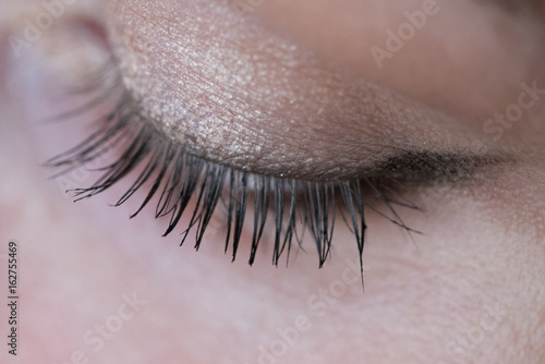 Closeup of woman's eye with soft makeup and long eyelashes