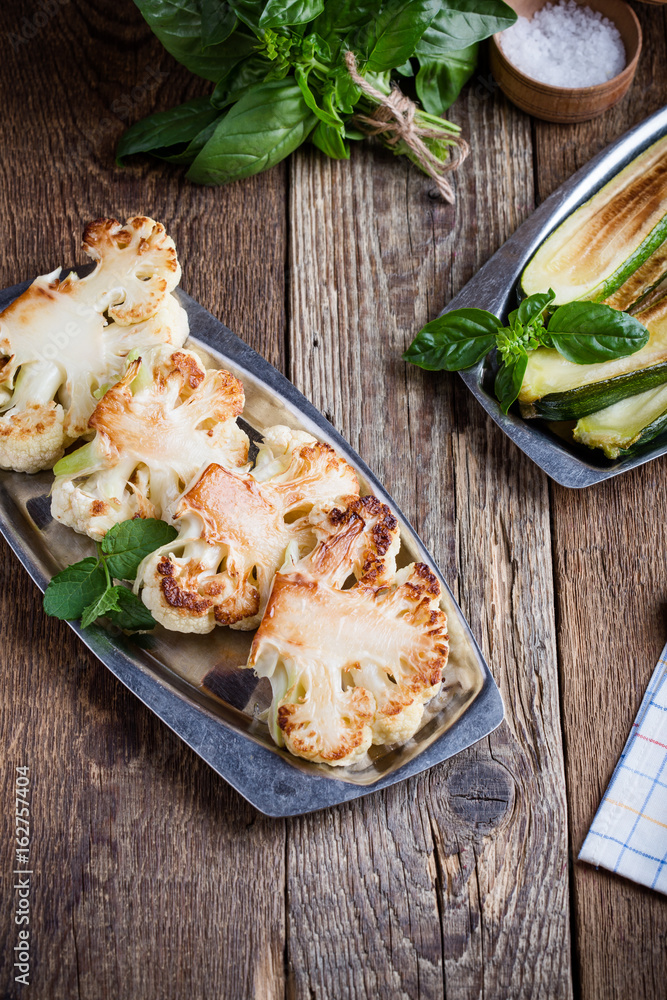 Roasted organic cauliflower steak on wooden board Roasted organic cauliflower steak on wooden board