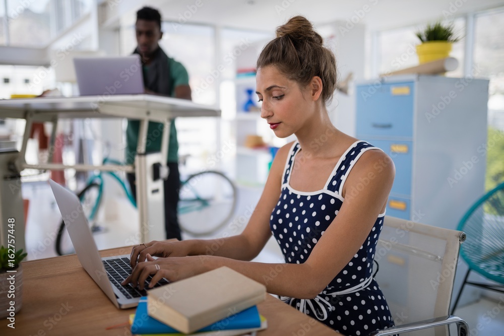 Female executive working on laptop at desk Female executive working on laptop at desk