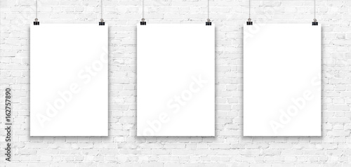 Three blank paper poster mockup on a white brick wall.
 photo