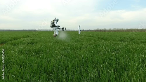 Spraying Fields With Herbicides . Farmer in Protective Clothing Working with a Sprayer