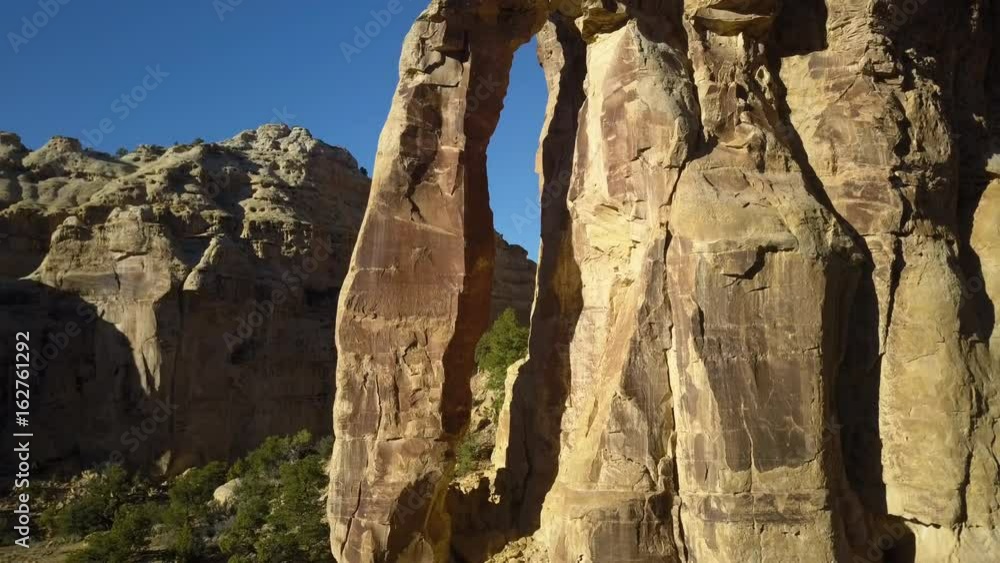 Aerial climb natural Eagle Canyon Arch Utah desert. Overhead drone view. San Rafael Reef is a geologic feature in central Utah. Eroded into tall fins, domes, cliffs, and deep canyons.