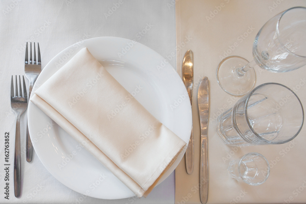Top view of the Cutlery in beige tones. Restaurant utensils for person. Classic Banquet table for a meal in the restaurant. Top view of the Cutlery in beige tones. Restaurant utensils for person. Classic Banquet table for a meal in the restaurant.
