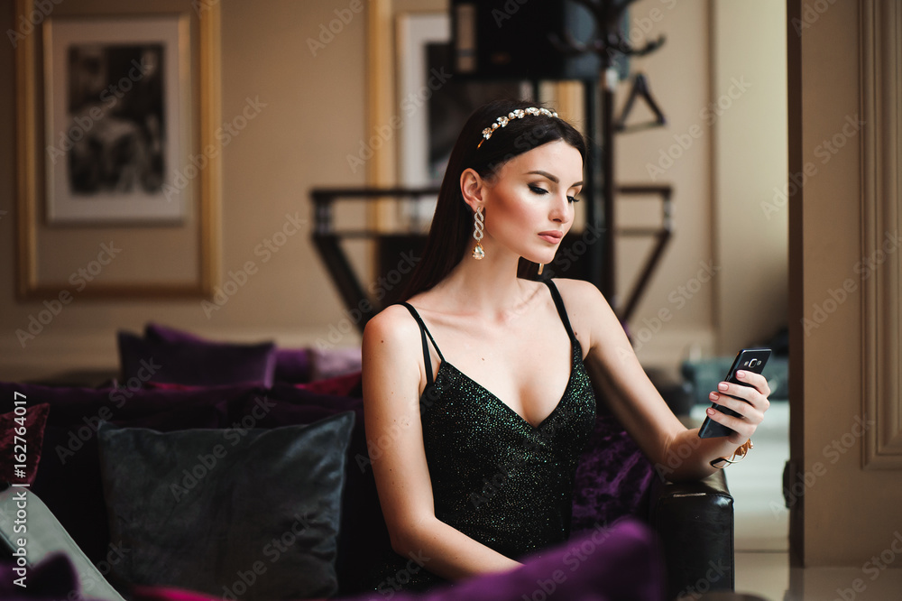 Fototapeta premium Beautiful brunette in hotel with mobile phone