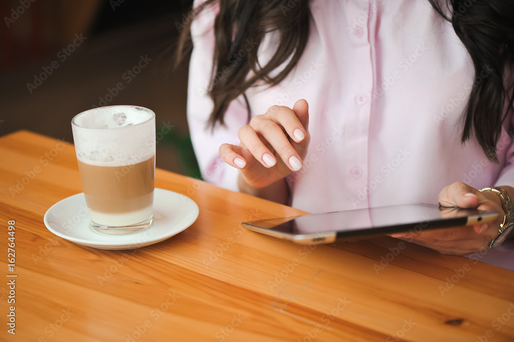 Close up hand woman using tablet in coffee shop Close up hand woman using tablet in coffee shop