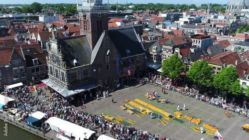 Aerial bird view flying backwards away from traditional Almaar Cheese Market a popular cultural destination for tourists and one of the most popular tourist attractions in Holland The Netherlands 4k photo