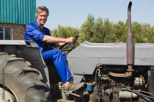 Smiling worker driving a tractor