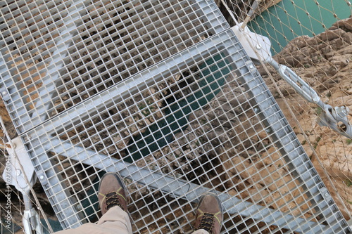 Hiker crossing the footbridge of the Los Gaitanes gorge, Caminito del Rey, Malaga, Spain