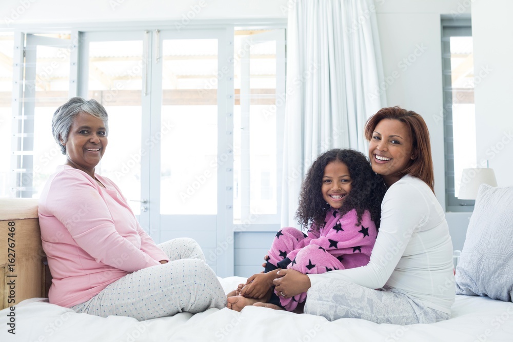 Happy family sitting on bed in bed room Happy family sitting on bed in bed room