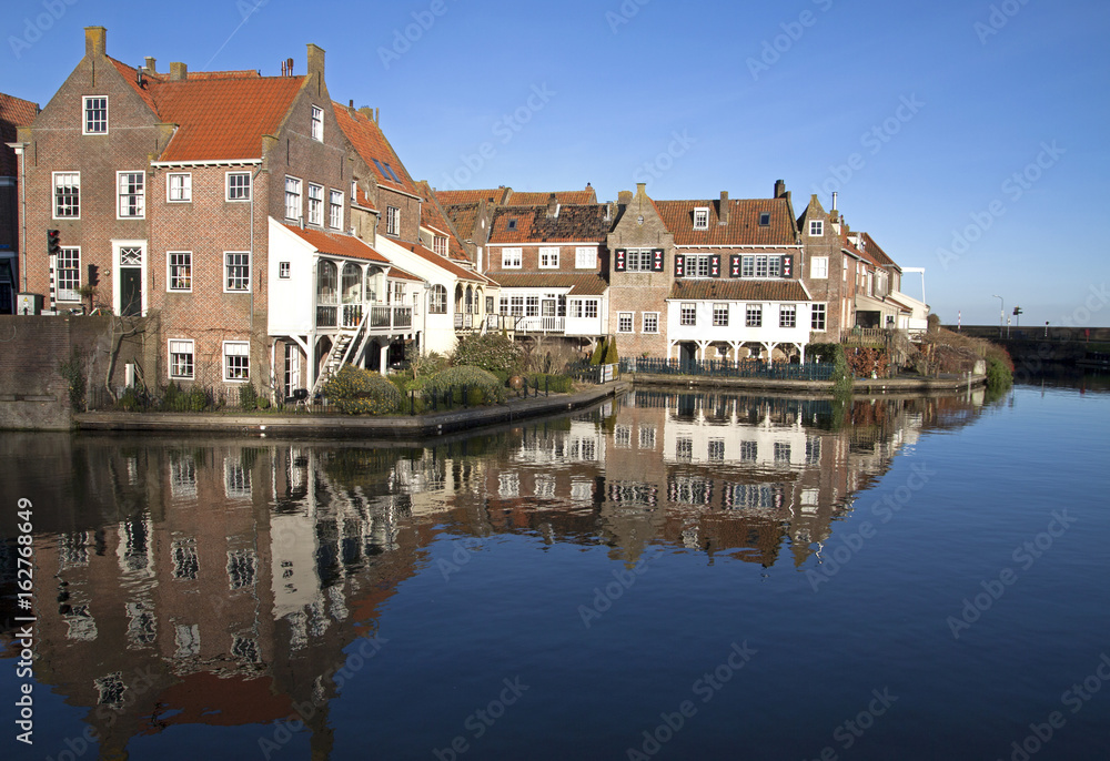 Old houses reflecting in the water in the small Dutch harbor town of Enkhuizen