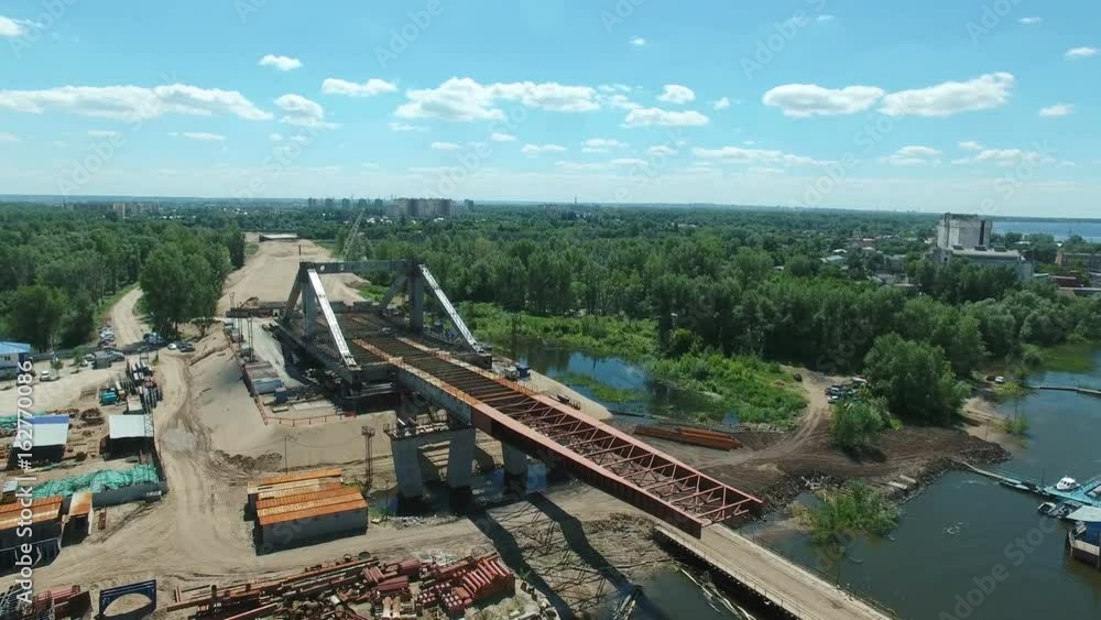 Aerial view of new bridge construction over Samara river against blue sky. Aerial stock footage shot at summer season time. Aerial view of new bridge construction over Samara river against blue sky. Aerial stock footage shot at summer season time.