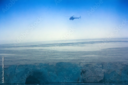 Helicopter over clouded Arctic glaciers. photo