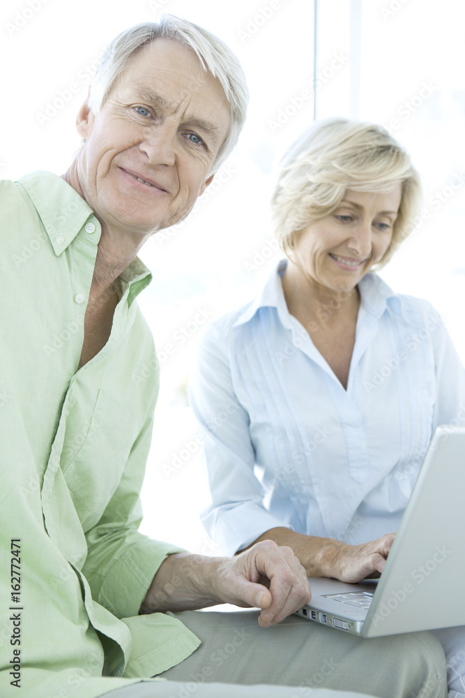Happy retired senior couple using laptop together Happy retired senior couple using laptop together