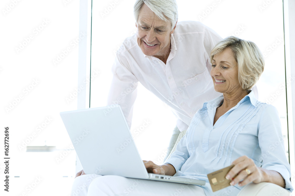 Happy retired senior couple using laptop together Happy retired senior couple using laptop together