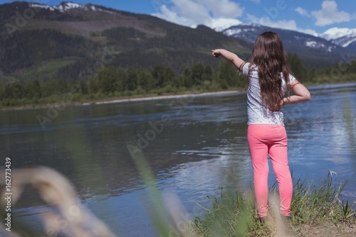 Rear view of girl pointing at mountain