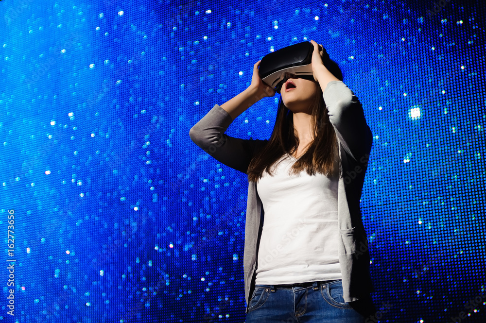 a beautiful girl wearing a virtual reality device, standing on the background of the sky a beautiful girl wearing a virtual reality device, standing on the background of the sky