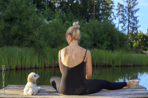 A pretty dancer with her dog on a pear