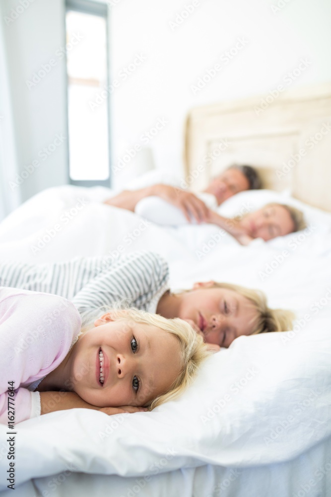 Family sleeping on bed in the bed room Family sleeping on bed in the bed room