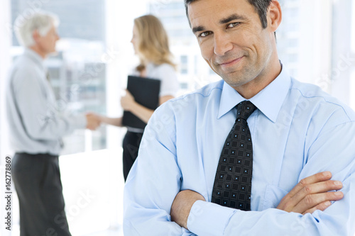 Portrait of a business manager with partners shaking hands