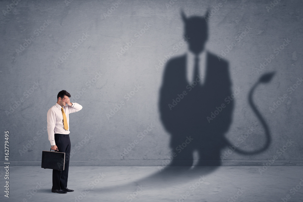 Fototapeta premium Business man looking at his own devil demon shadow concept