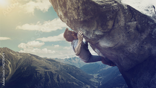 Mann klettert auf einen Berg photo